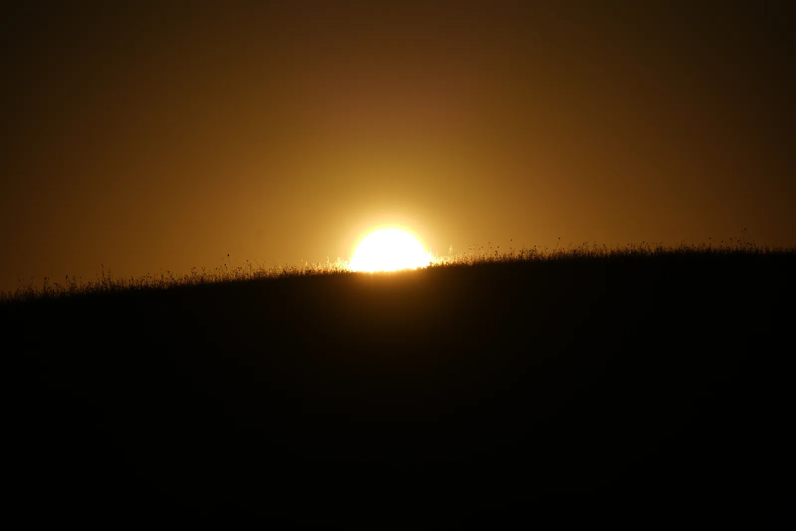 Soleil apparaissant derrière une crête au lever du jour